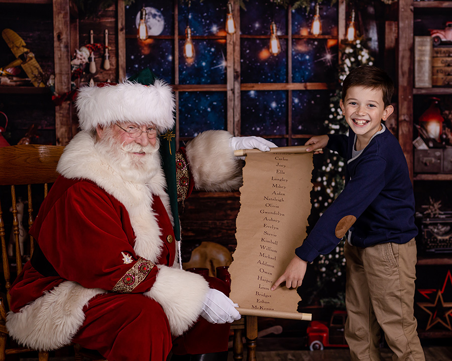 boy pointing to the nice list with Santa Claus