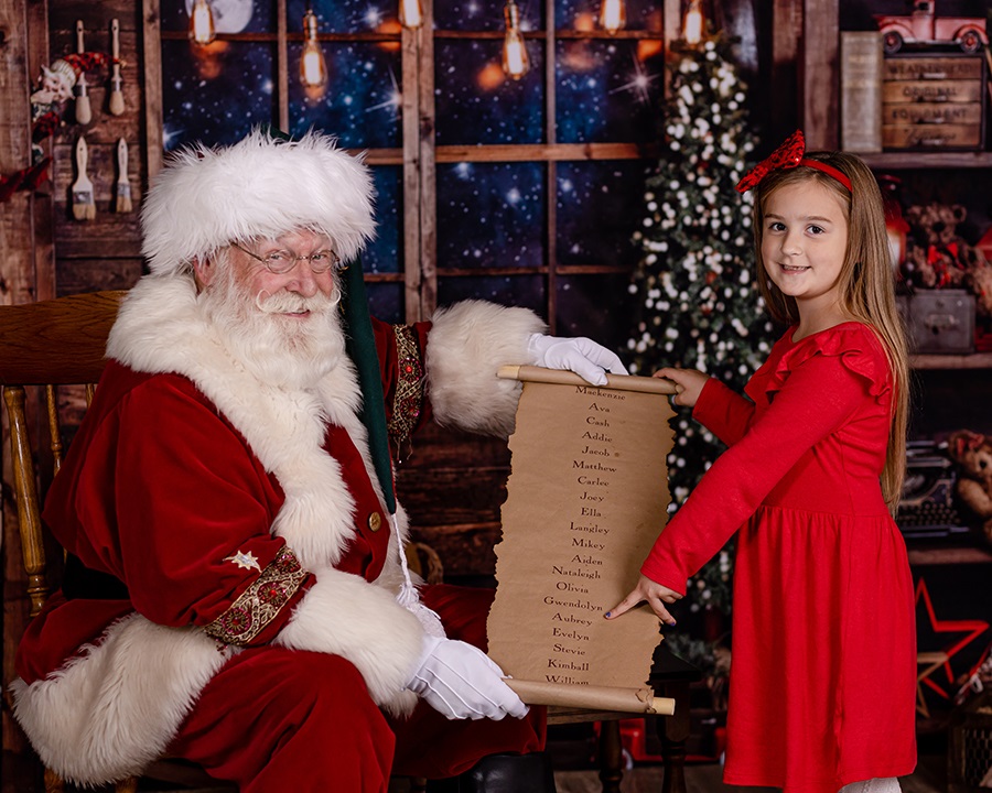 santa with girl pointing to the nice list