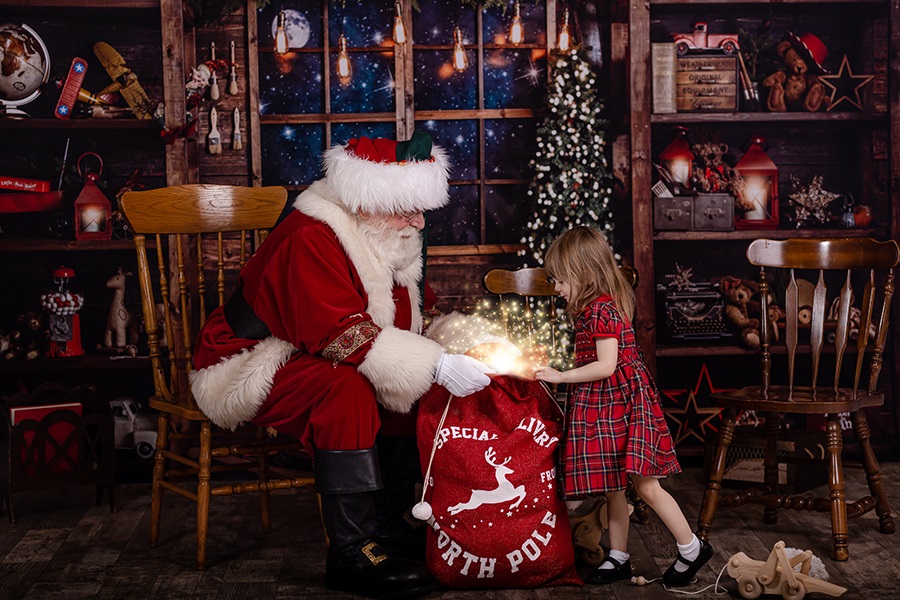 little girl looking into santa's toy bag
